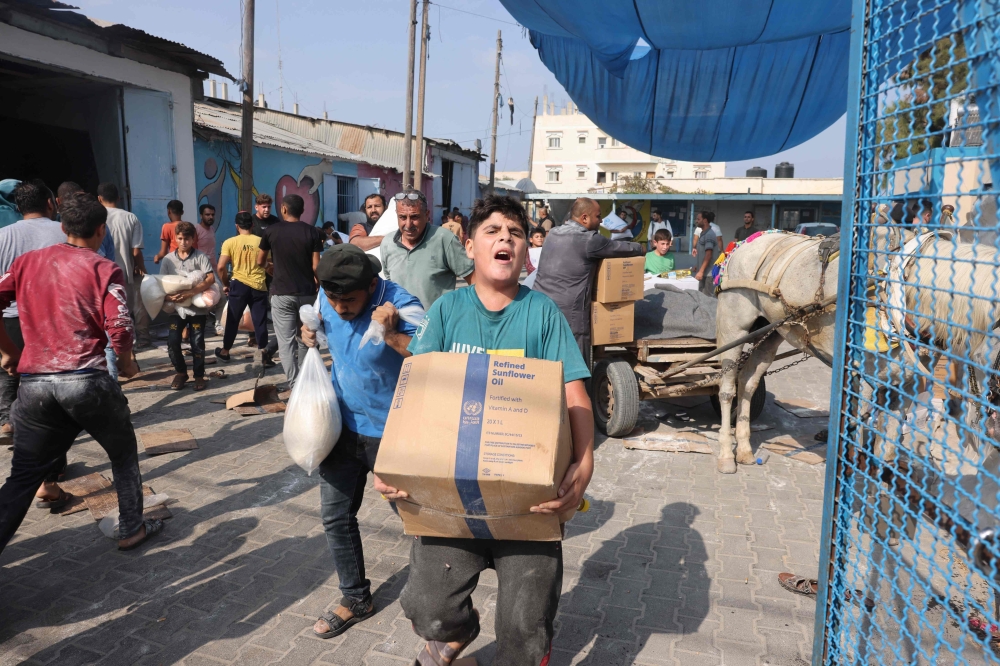 Thousands of Gaza residents broke into UN warehouses yesterday, grabbing flour and other essential items in a sign they had reached breaking point, the United Nations Palestinian refugee agency (UNRWA) said. — AFP pic