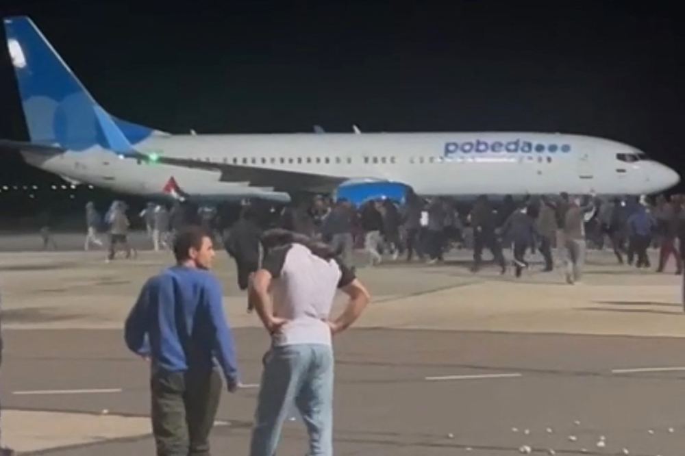This frame grab taken from a video footage posted on the Telegram channel @askrasul on October 29, 2023 shows protestors running on the apron area in the airport in Makhachkala. — AFP pic/Telegram channel @askrasul