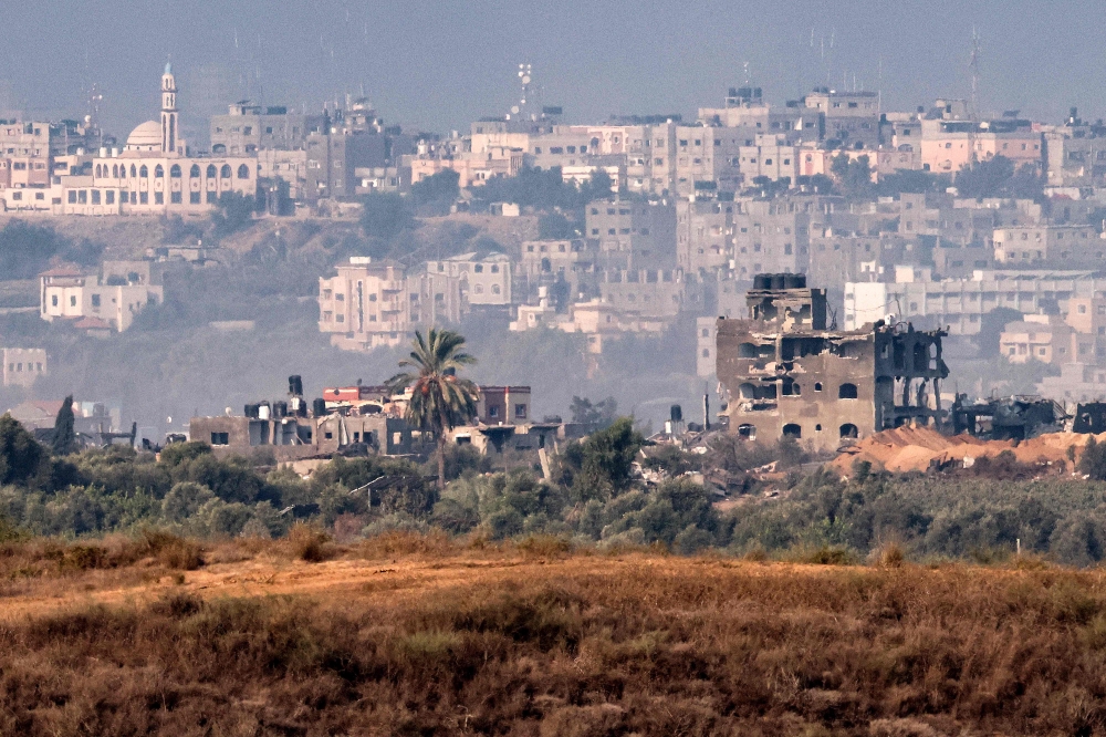 This picture taken on November 1, 2023 from a position along the border with the Gaza Strip in southern Israel shows buildings destroyed by Israeli bombardment on the backdrop of the Gaza skyline amid ongoing battles between Israel and the Palestinian Hamas movement. — AFP pic