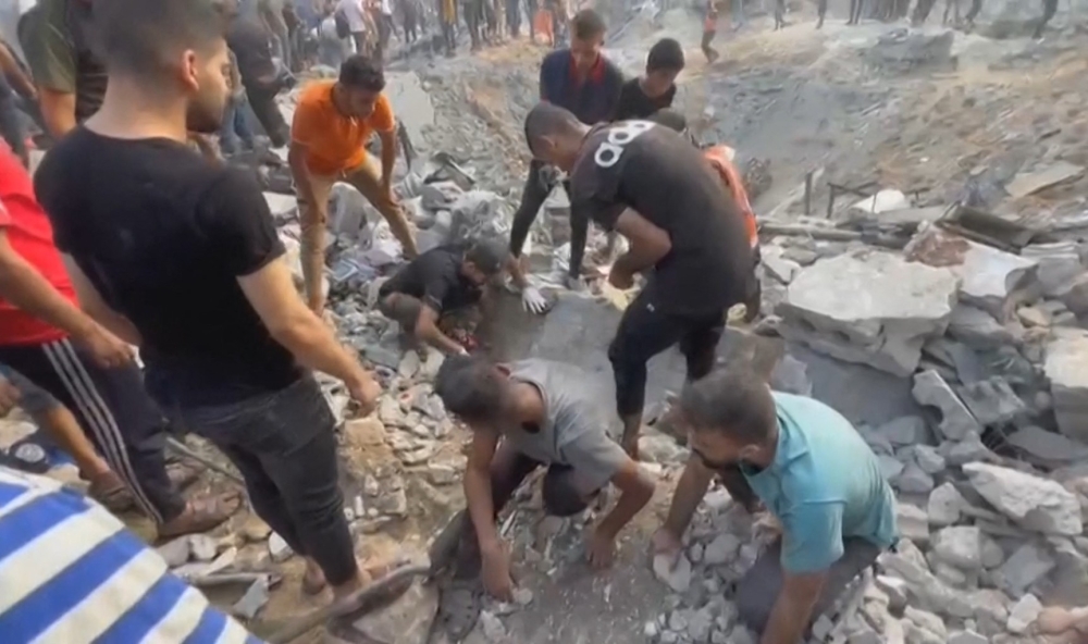 This image grab taken from AFPTV video footage shows Palestinians looking for survivors in a crater following an Israeli strike on a refugee camp in Jabalia on the southern Gaza Strip, on October 31, 2023, amid ongoing battles between Israel and the Palestinian Hamas movement. — AFP pic