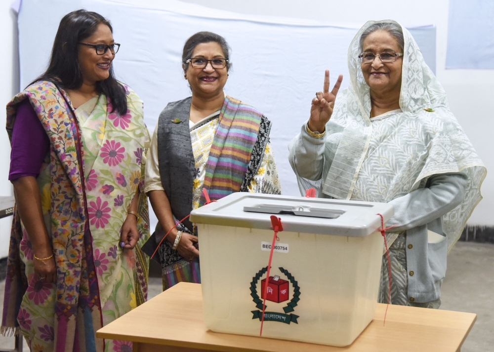 Bangladeshi Prime Minister Sheikh Hasina (right) flashes the victory symbol after casting her vote, as her daughter Saima Wazed (left) and her sister Sheikh Rehana (2nd left) look on at a polling station in Dhaka on December 30, 2018. The World Health Organisation on November 1 selected the daughter of Bangladesh’s prime minister to be its South-East Asia director, a month after she rejected criticisms of nepotism over her application. — AFP pic