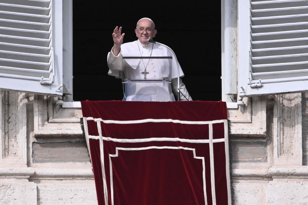 Pope Francis waves from the window of the apostolic palace overlooking St. Peter's square during the weekly Angelus prayer on October 29, 2023 in The Vatican. — AFP pi
