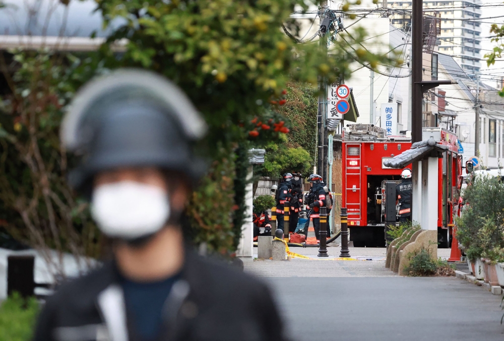 Police officers guard the area around a post office where a suspected gunman has taken an unknown number of people hostage in Warabi city, Saitama prefecture on October 31, 2023. — AFP pic