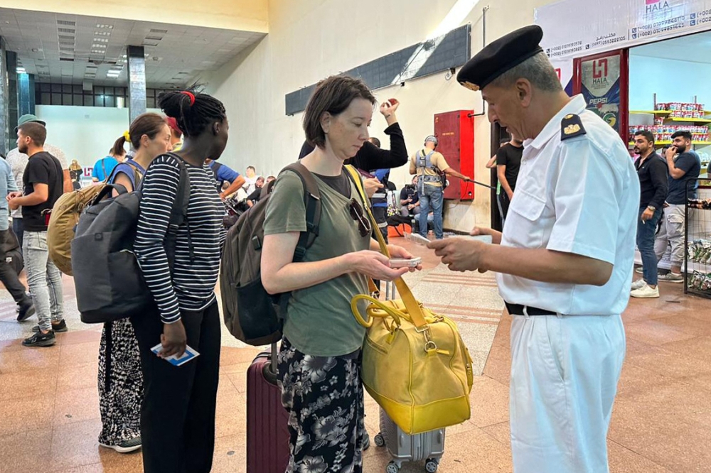 An Egyptian officer speaks with a foreign passport holder upon arriving in the Egyptian part of the Rafah border crossing with the Gaza Strip November 1, 2023. — AFP pic