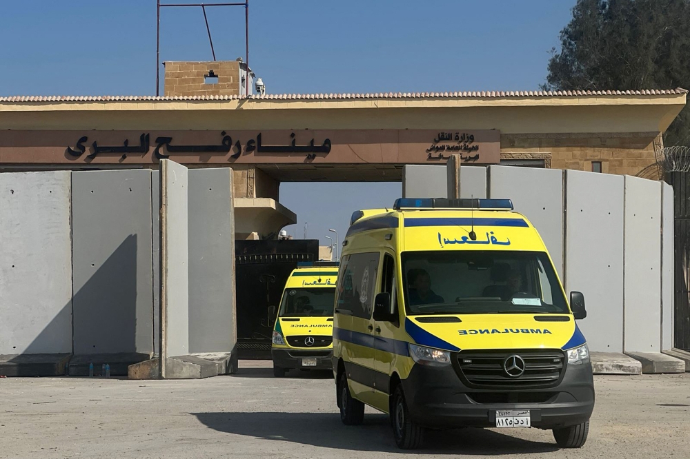 Ambulances cross back into the Egyptian side of the border with the Gaza Strip in Rafah, on November 1, 2023, as they transport wounded to Egyptian field hospital. — AFP pic