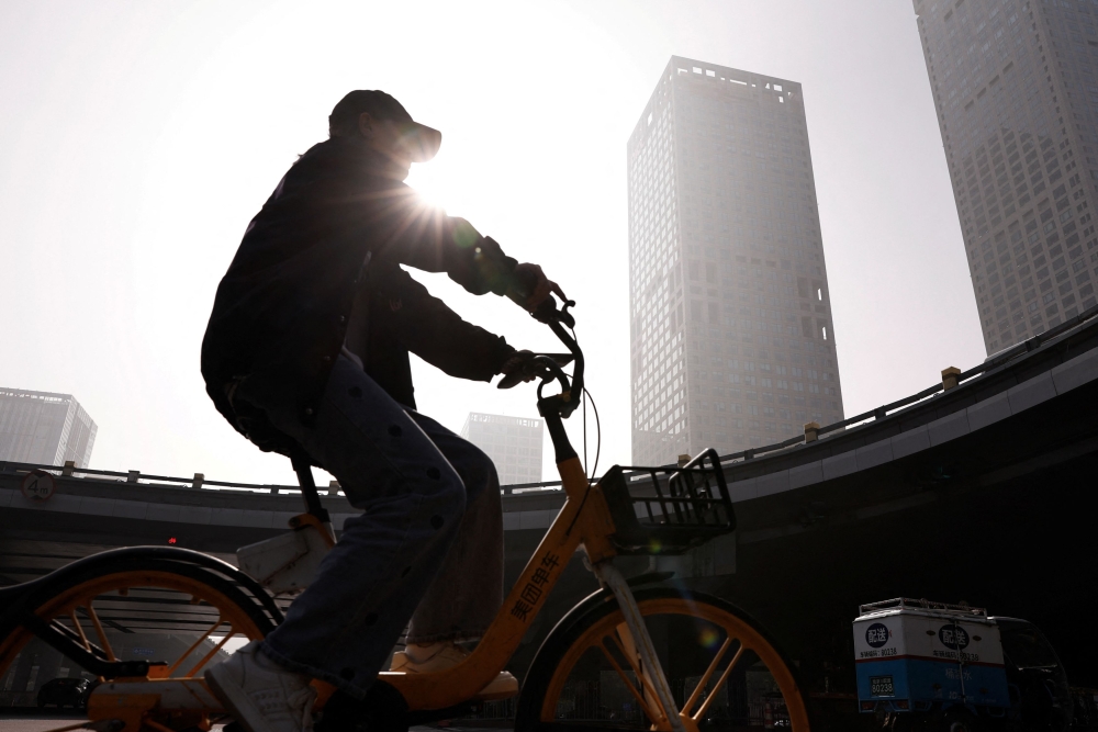 A person rides a bike past Beijing's Central Business District (CBD), as the city is shrouded in smog, in China November 1, 2023. — Reuters pic