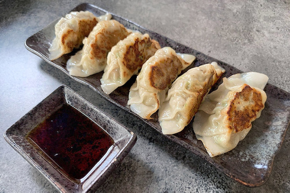 Pan-fried 'gyoza', served with the requisite saucer of vinegar.