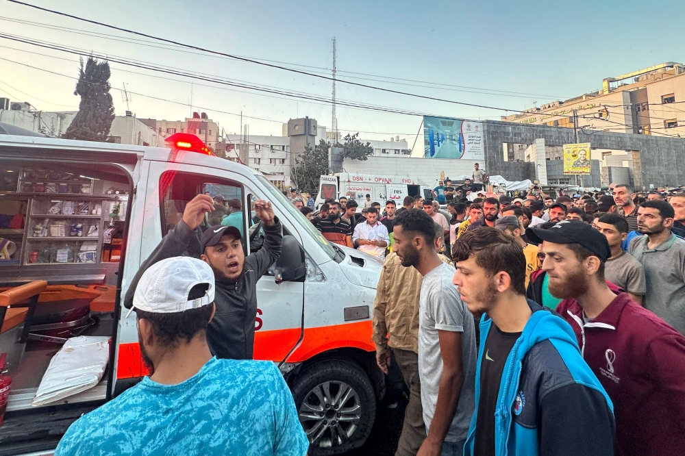 People gather around an ambulance damaged in a reported Israeli strike in front of Al-Shifa hospital in Gaza City on November 3, 2023, as battles between Israel and the Palestinian Hamas movement continue. — AFP pic