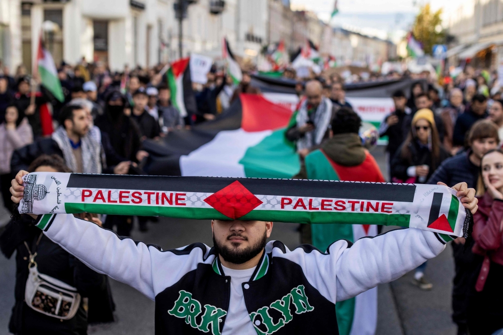 A demonstrator displays a scarf with the lettering 'Palestine' during a rally in solidarity with the Palestinians in the Gaza Strip in Warsaw, Poland on October 29, 2023. — AFP pic