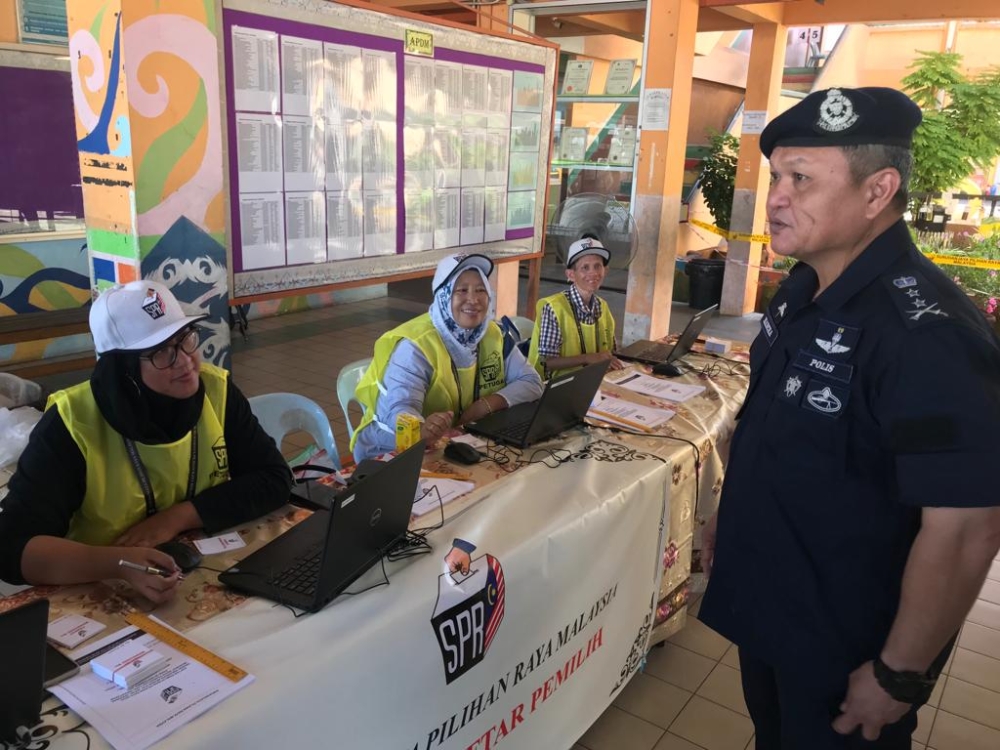 Sarawak deputy police commissioner Datuk Mancha Ata inspecting the voting process at the SK Bintulu polling station. ― Borneo Post pic