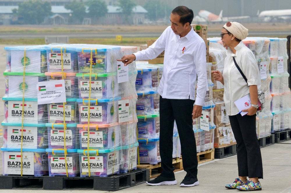 Indonesia’s President Joko Widodo (left) and Foreign Affairs Minister Retno Marsudi inspect shipments of humanitarian aid, provided by the Indonesian government to the Palestinian people, before their departure from an air force base in Jakarta on November 4, 2023. — AFP pic