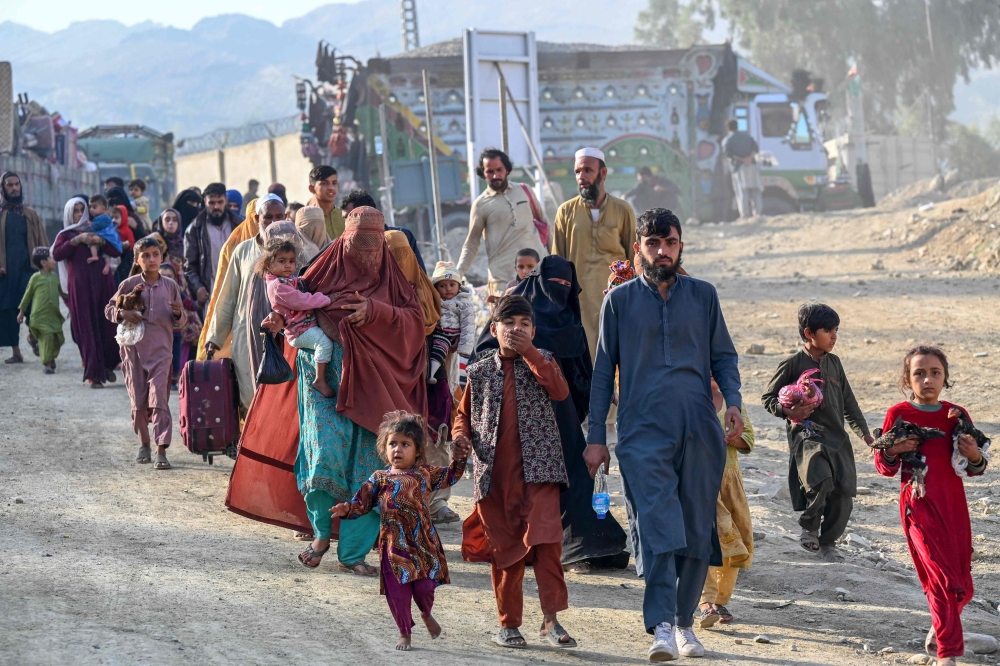Afghan refugees in Pakistan walk towards the Pakistan-Afghanistan Torkham border on November 3, 2023, following Pakistan's government decision to expel people illegally staying in the country. — AFP pic