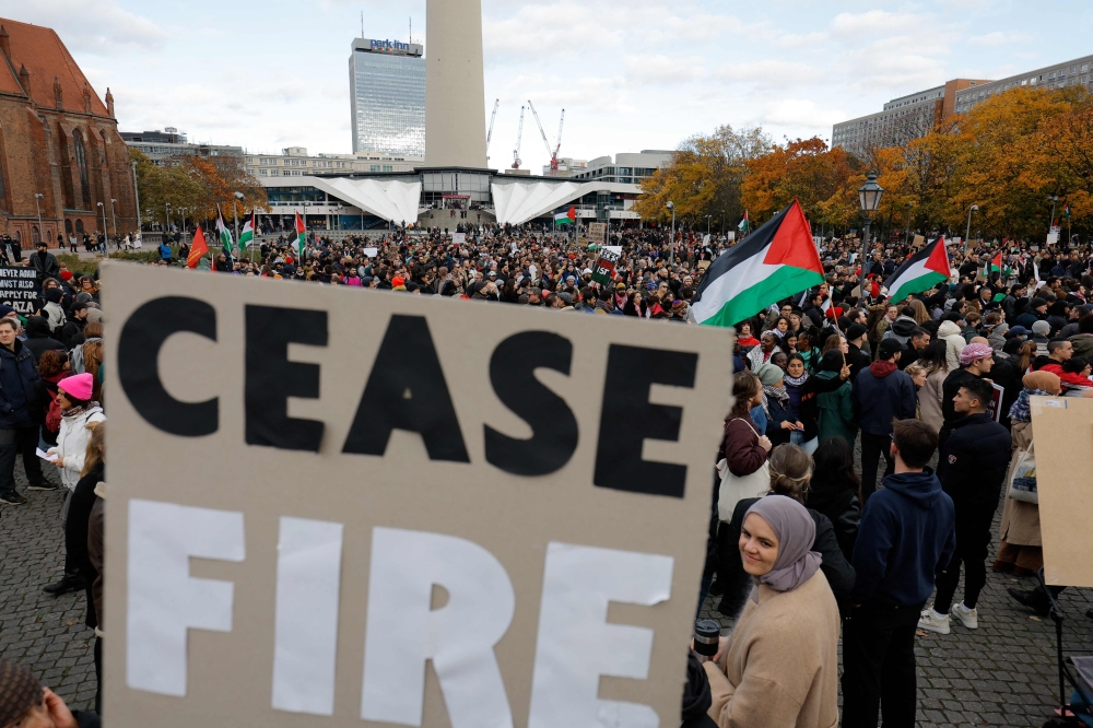 Participants wave the Palestinian flag during a protest in support of Palestinians under the slogan ‘Free Palestine’ in Berlin, Germany on November 4, 2023, while a placard with the lettering 'Ceasefire' is seen in the foreground. — AFP pic