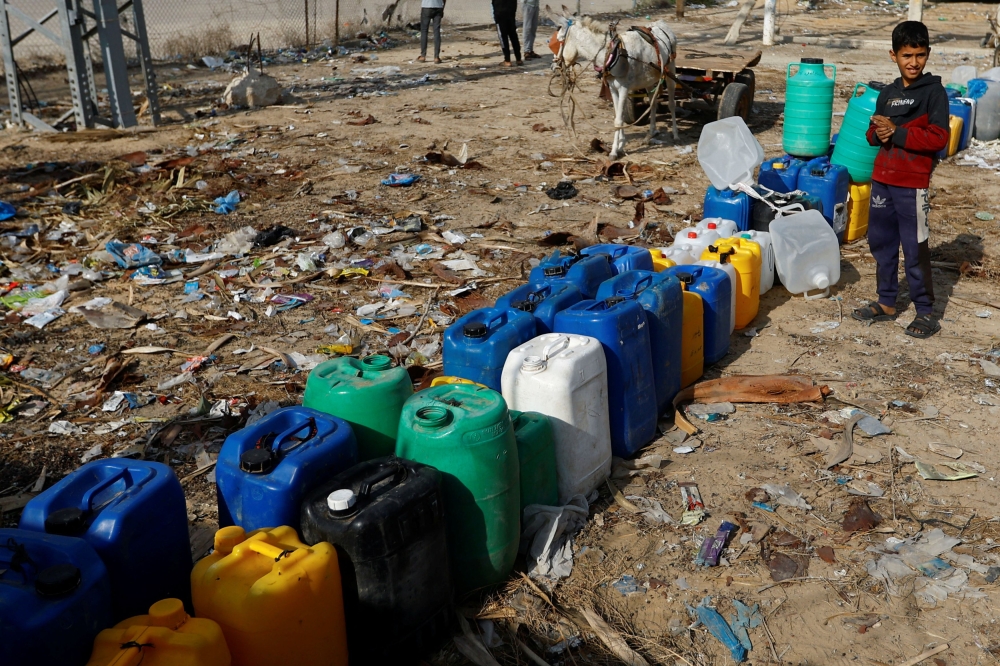 A child stands next to containers, as Palestinians collect water, amid a lack of clean and drinking water, as the conflict between Israel and Palestinian Islamist group Hamas continues, in Rafah, in the southern Gaza Strip, November 5, 2023. — Reuters pic