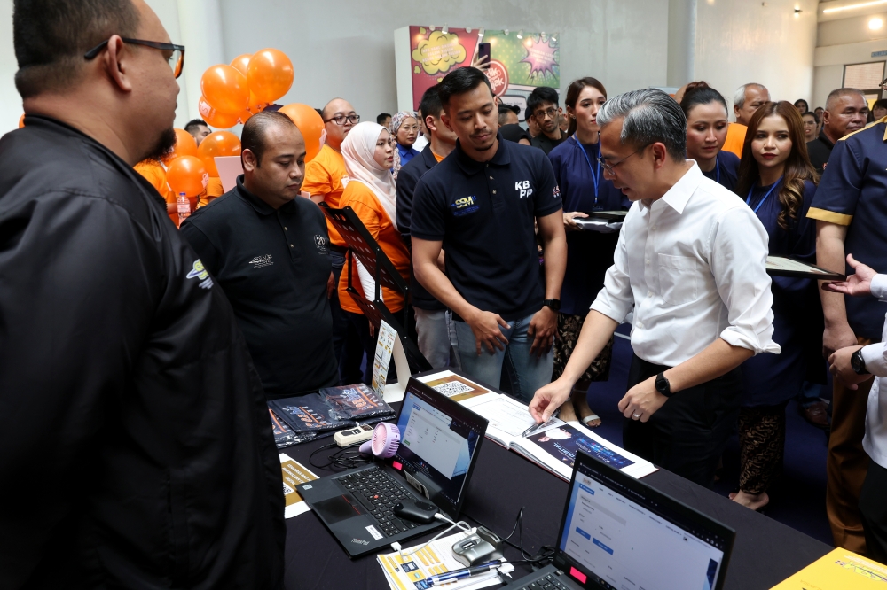 Minister of Communications and Digital Fahmi Fadzil stopping by the exhibition booth during the Opening Ceremony of the Empowerment of People with Disabilities (OKU) Digital Literacy Program at IWK Eco Park Community Center, Kuala Lumpur, November 5, 2023. — Bernama pic