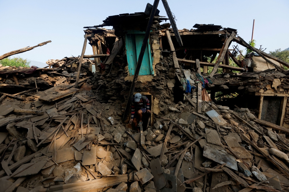 A man walks out from the door of his house as he salvages goods from his collapsed house after an earthquake in Jajarkot, Nepal November 6, 2023. — Reuters pic