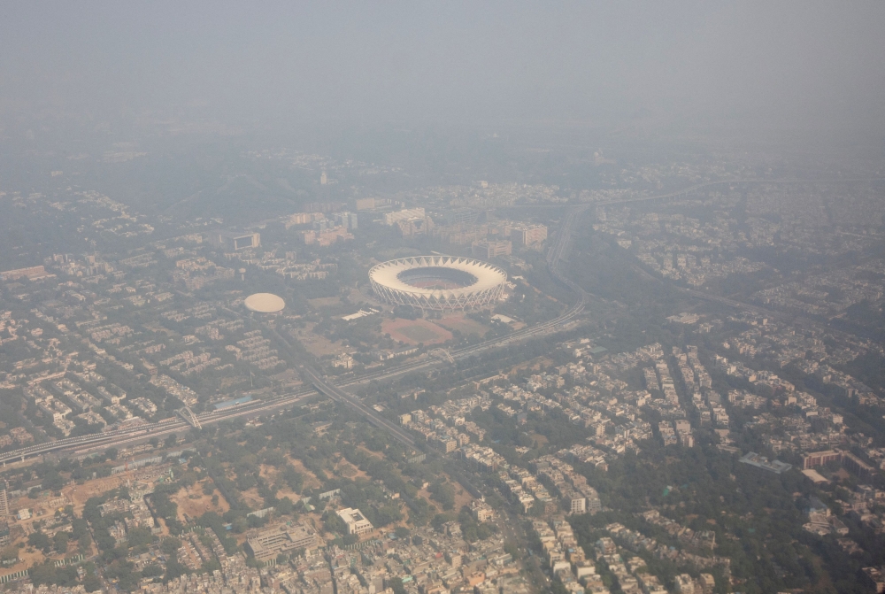 An aerial view shows residential buildings and a stadium shrouded in smog in New Delhi, India, October 27, 2023. — Reuters pic
