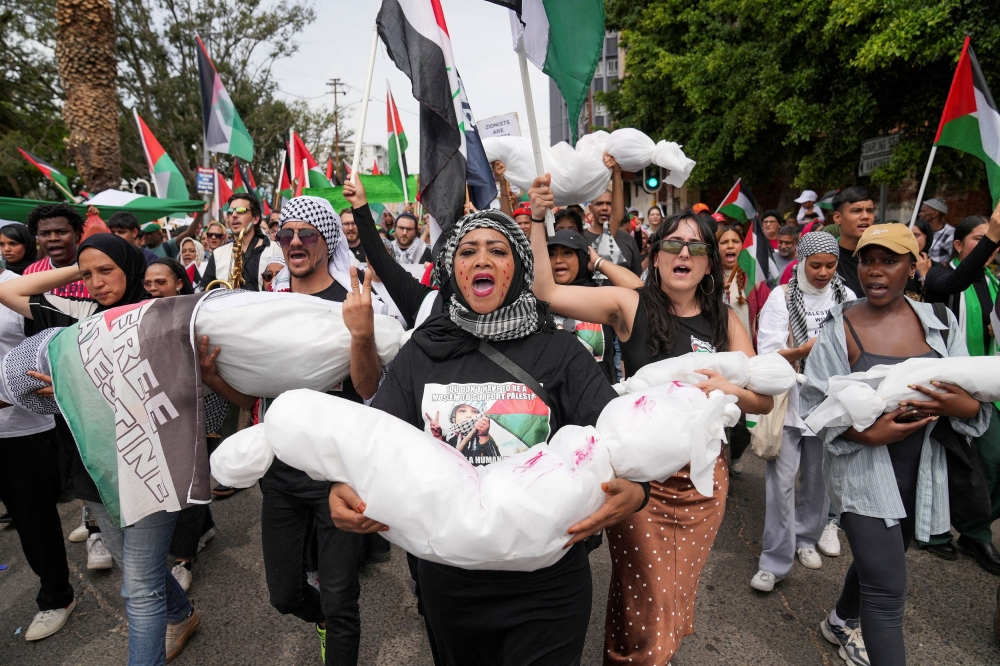 Demonstrators carry fake bodies wrapped in cloth during a protest in support of Palestinians, as they march to the Cape Town City Hall, amid the ongoing conflict between Israel and Palestinian Islamist group Hamas, in Cape Town, South Africa November 1, 2023. — Reuters pic