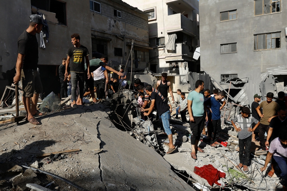 Palestinians gather at the site of an Israeli strike on a house, amid the ongoing conflict between Israel and Palestinian Islamist group Hamas, in Khan Younis in the southern Gaza Strip, November 6, 2023. — Reuters pic