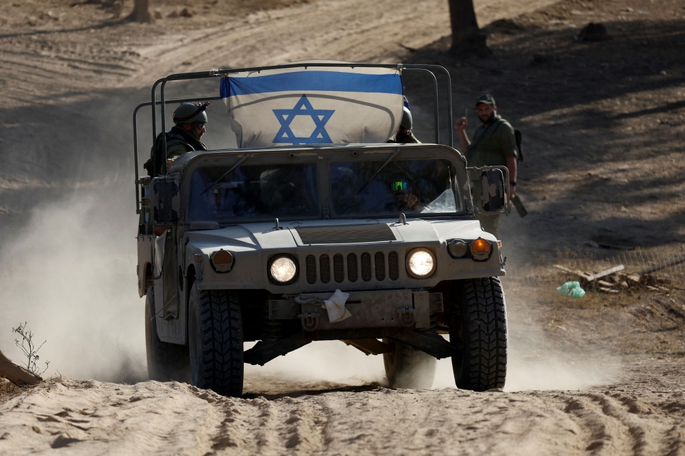 An Israeli military vehicle rides at an undisclosed location near the Gaza Strip border, amid the ongoing conflict between Israel and Palestinian Islamist group Hamas, in Israel, November 6, 2023.  ― Reuters pic