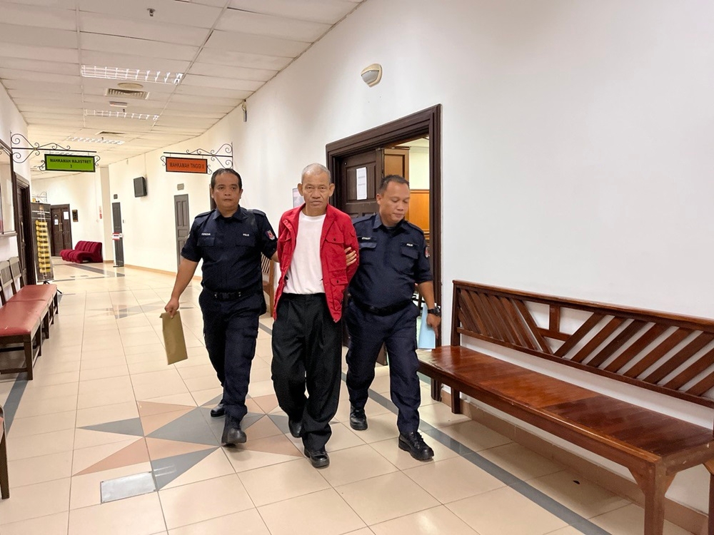 Policemen escort Nuli after sentencing at the Kuching Court Complex. — Borneo Post Online pic