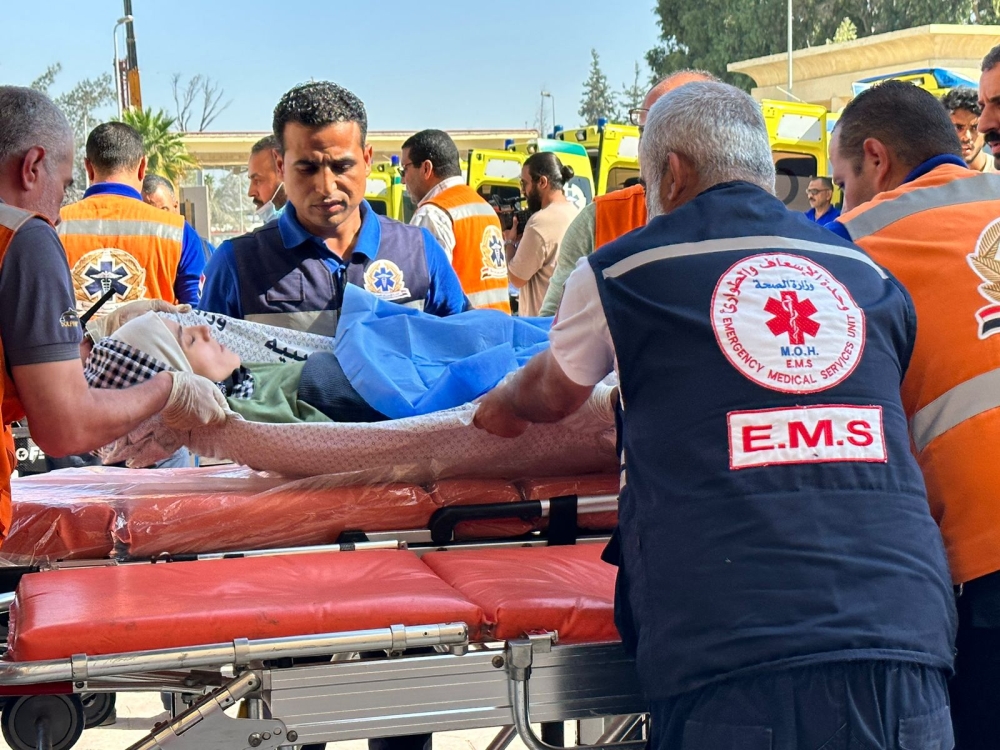 Egyptian paramedics transfer an injured Palestinian woman on the Egyptian side of the Rafah border crossing with the Gaza Strip, in the north eastern Sinai province, on November 7, 2023 amid ongoing battles between Israel and the Palestinian Hamas movement. — AFP pic