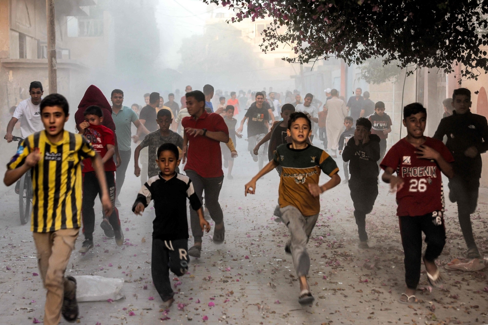 Palestinian children run as they flee from Israeli bombardment in Rafah in the southern Gaza Strip on November 6, 2023, amid continuing battles between Israel and the Palestinian militant group Hamas. — AFP pic