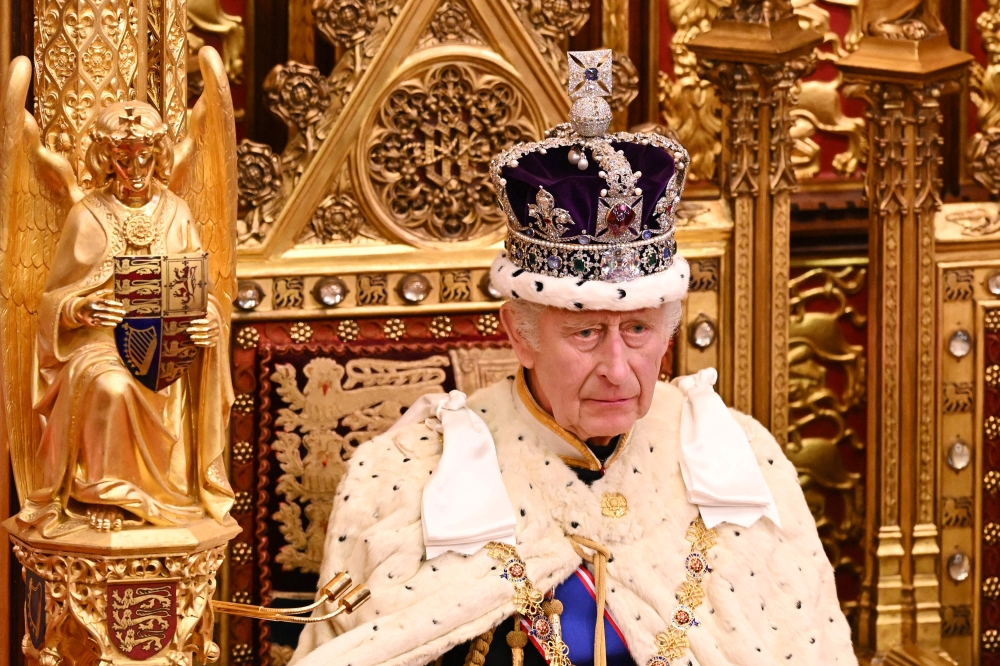 Britain's King Charles III, wearing the Imperial State Crown and the Robe of State, sits on The Sovereign's Throne in the House of Lords chamber, during the State Opening of Parliament, at the Houses of Parliament, in London, on November 7, 2023. — AFP pic
