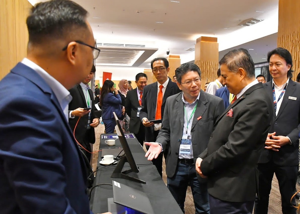 Mohd Arifin chatting with an exhibitor at the BIMP-EAGA Cyber Security Summit 2023. — Borneo Post Online pic