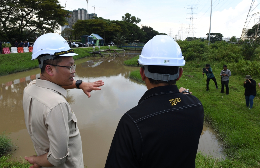 Natural Resources, Environment and Climate Change Minister Nik Nazmi Nik Ahmad (left) inspects the site of the Taman Siakap Flood Mitigation project in Butterworth November 8, 2023. — Bernama pic