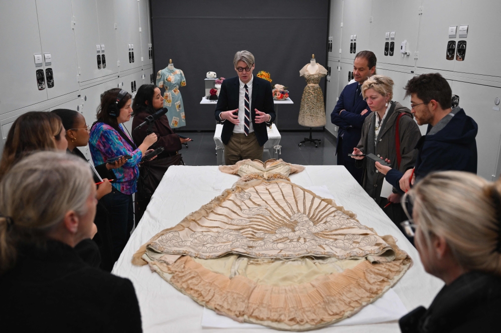 Head curator of the Anna Wintour Costume Center at the Metropolitan Museum of Art Andrew Bolton speaks at The Metropolitan Museum of Art. Fanned out on a large table is the full silk satin House of Worth ball gown from the late 19th century, its embroidery, beads and sequins still resplendent despite the years. — AFP pic 