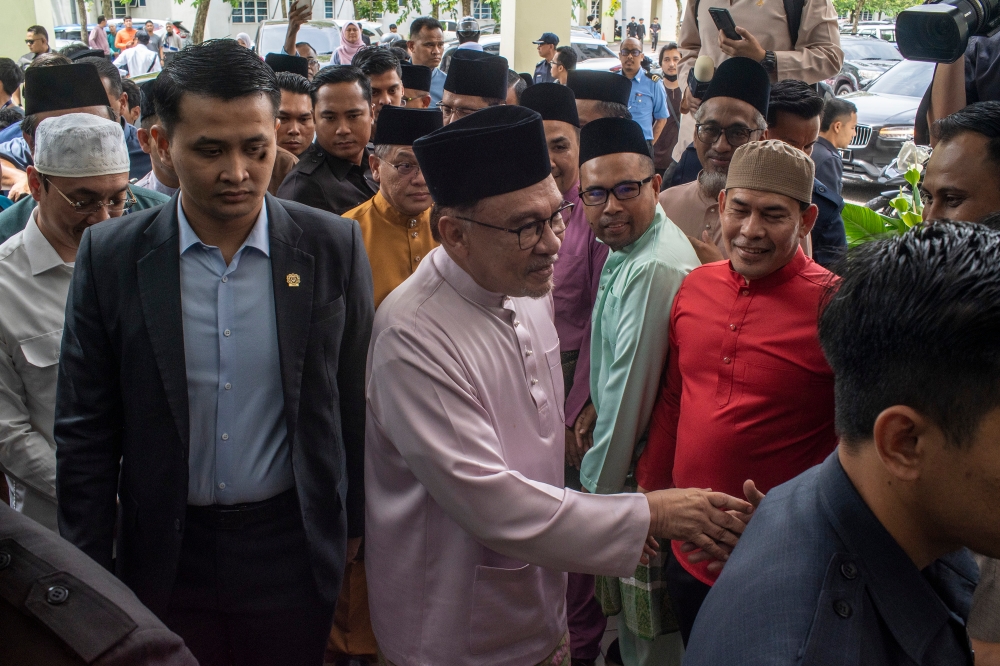 Prime Minister Datuk Seri Anwar Ibrahim greets people during at Musolla Asy-Syafi, Sultan Idris Shah hospital in Serdang on 10 November 2023. —Picture by Shafwan Zaidon