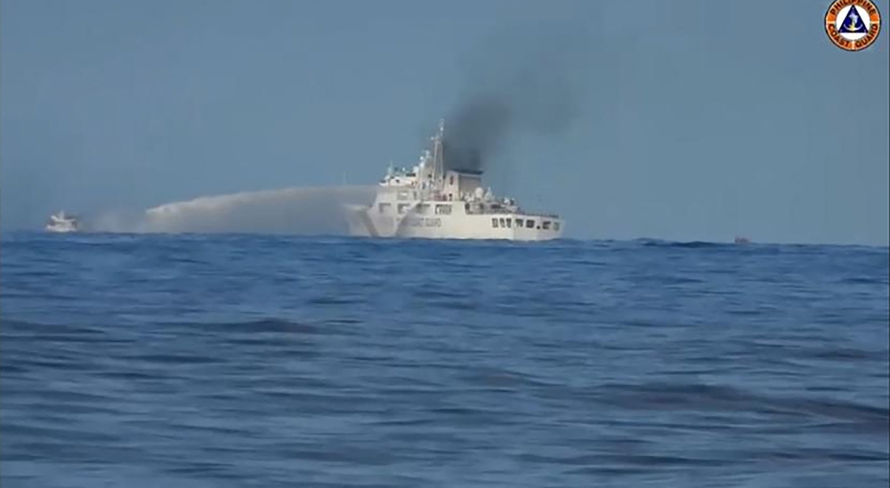 This handout video grab made from a footage released by the Philippine Coast Guard (PCG) on November 11, 2023 shows a Chinese Coast Guard ship (right) firing its water cannon on one of the Philippine supply boats, near Second Thomas Shoal, in the disputed South China Sea. ― AFP pic