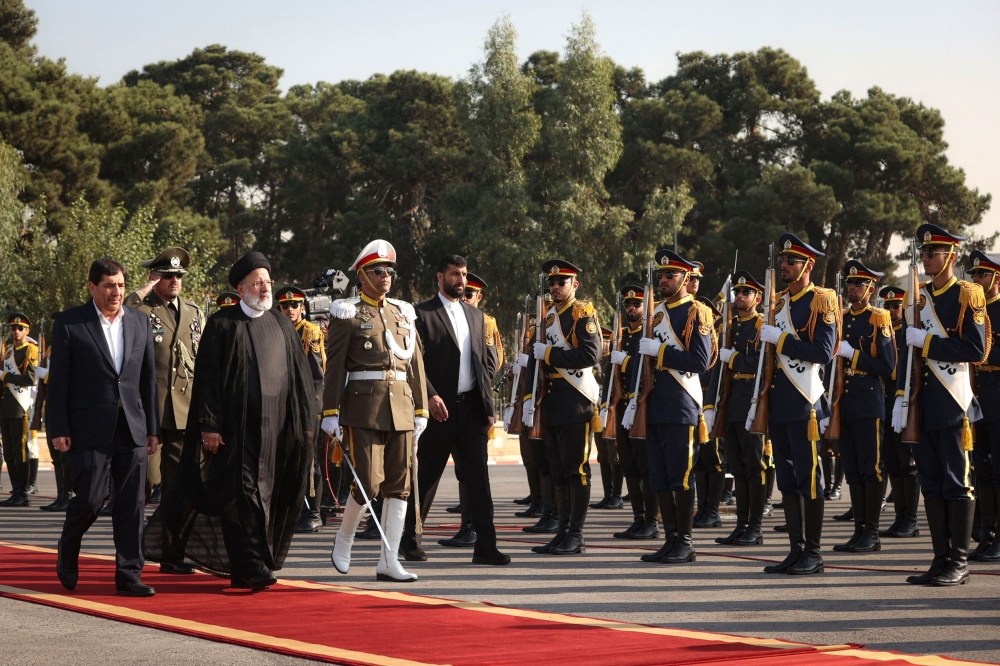 This handout picture provided by the Iranian Presidency on November 11, 2023, shows Iran’s President Ebrahim Raisi being escorted by government officials to a waiting aircraft departing from Tehran's Mehrabad International Airport to Saudi Arabia to attend a summit.. ― Reuters pic