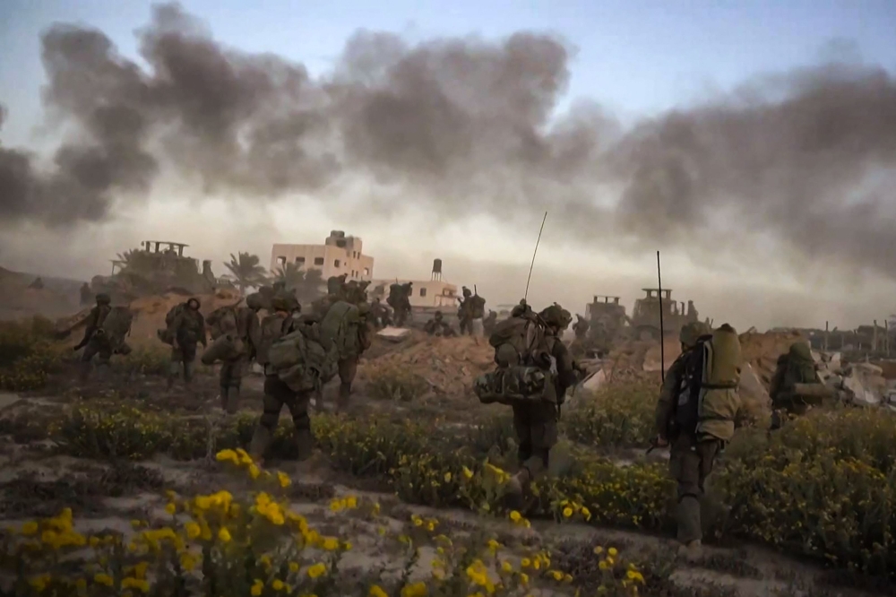 This file photo from a handout video released by the Israeli army on November 11, 2023, shows smoke rising as Israeli forces patrol inside the Gaza Strip. ― AFP pic