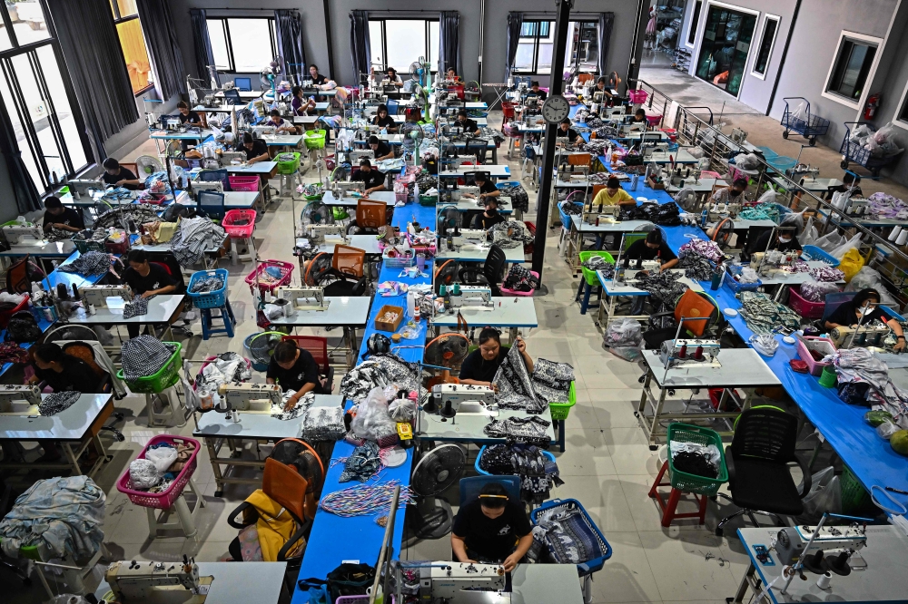 Workers sewing clothing with elephant print and other patterns at Chinrada Garment Co in Chiang Mai. — AFP pic