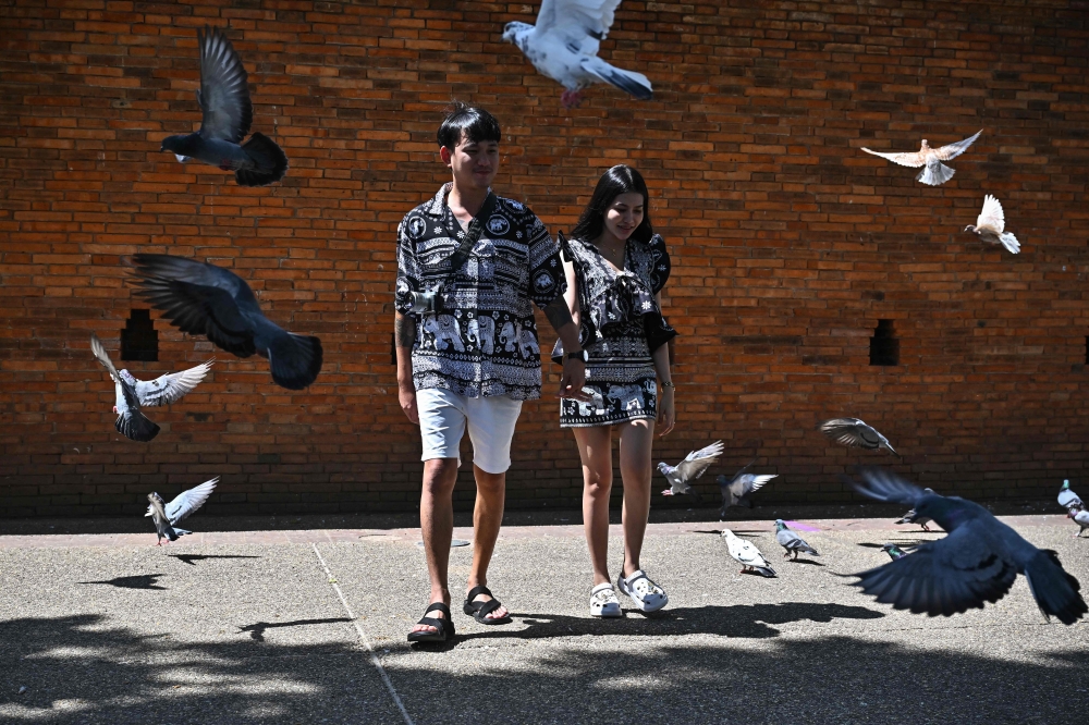 A Thai couple wearing elephant print clothing near Thapae Gate in the northern Thai province of Chiang Mai. — AFP pic