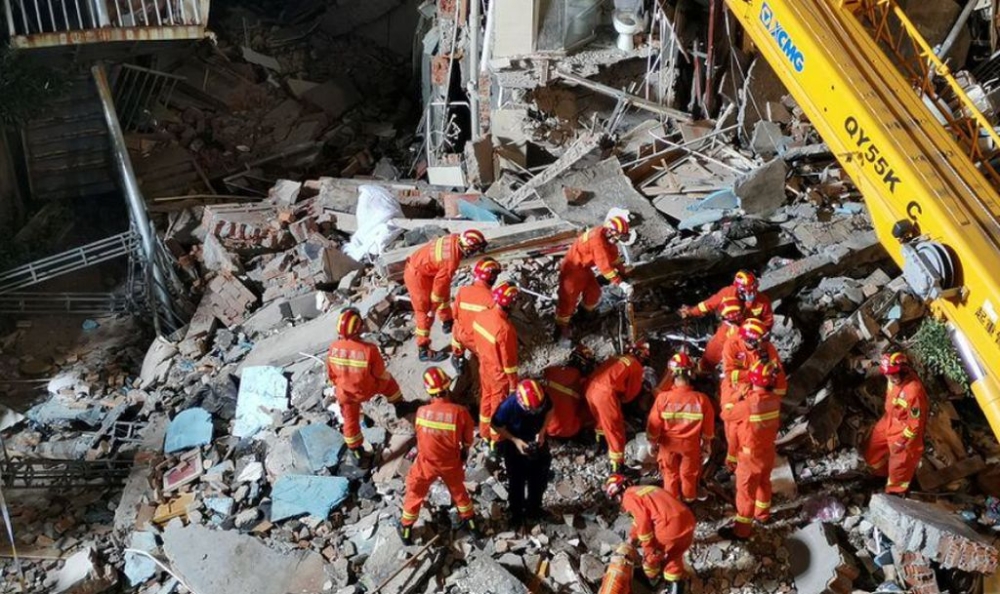 Rescue workers work next to a crane at the site where a hotel building collapsed in Suzhou, Jiangsu province, China July 12, 2021. — Reuters file pic