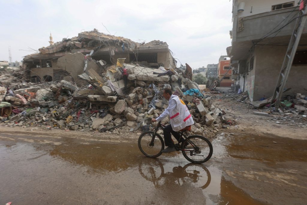 File picture shows Palestinian doctor Hassan Zain al Din travelling on his bicycle from one makeshift shelter to another to provide treatment and medication to displaced patients, riding past the rubble amid fuel shortages, as the conflict between Hamas and Israel continues, in Deir al-Balah, in the central Gaza Strip October 29, 2023. — Reuters pic