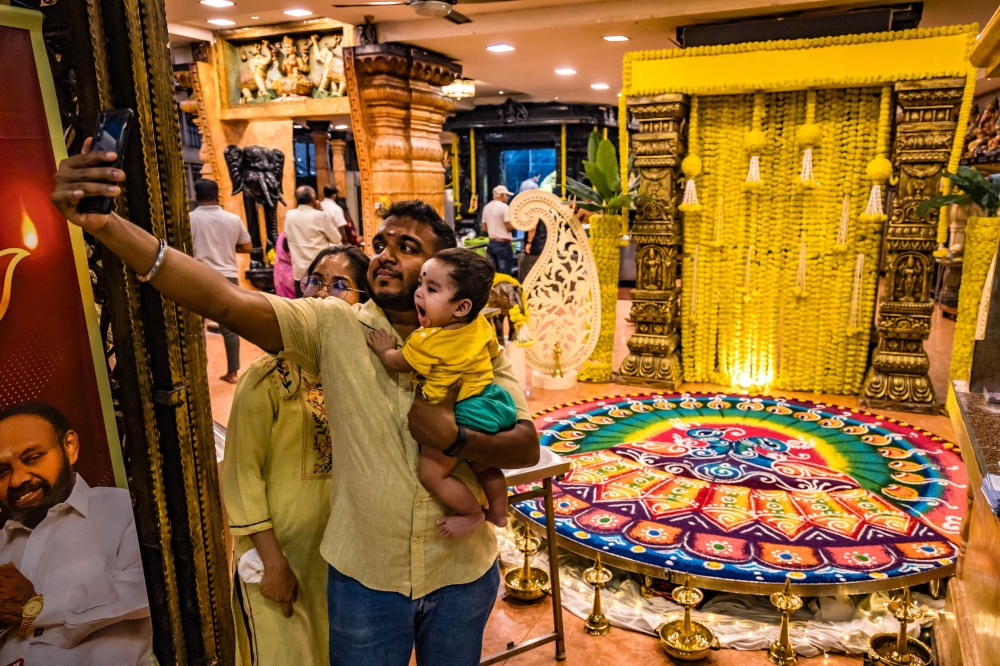 A family takes a selfie with Kolam decorations on the eve of Deepavali at Court Hill Sri Ganesar Temple in Kuala Lumpur November 11, 2023. — Picture by Firdaus Latif