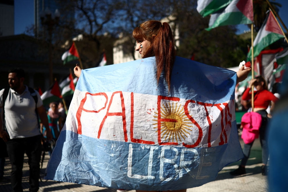A woman holds an Argentine flag that reads 'Free Palestine' as members of Argentine human rights and Islamic organizations march in solidarity with Palestinians in Gaza demanding an immediate ceasefire, in Buenos Aires, Argentina November 11, 2023. — Reuters pic