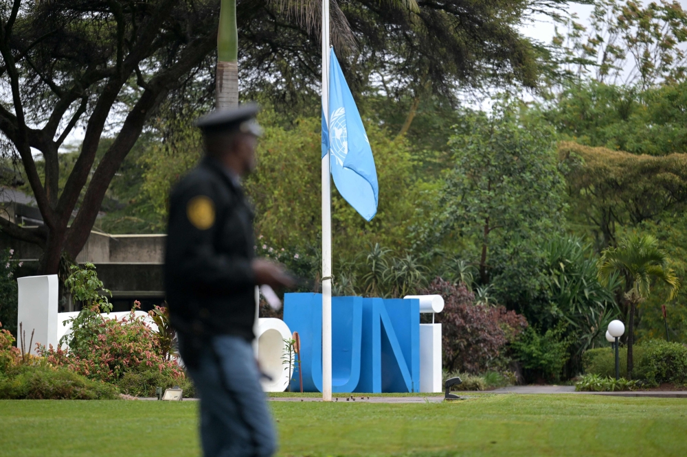 A security official looks on as the United Nations flag flies at half-mast to mourn the lives of UN workers lost during the war between Israel and Hamas, at the at the United Nations office in Nairobi. — AFP pic