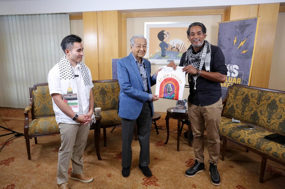 Tun Dr Mahathir Mohamad (centre) poses for a group photo with ‘Keluar Sekajap’ podcast hosts Khairy Jamaluddin (right) and Shahril Hamdan (left). — Picture via Facebook/Keluar Sekejap
