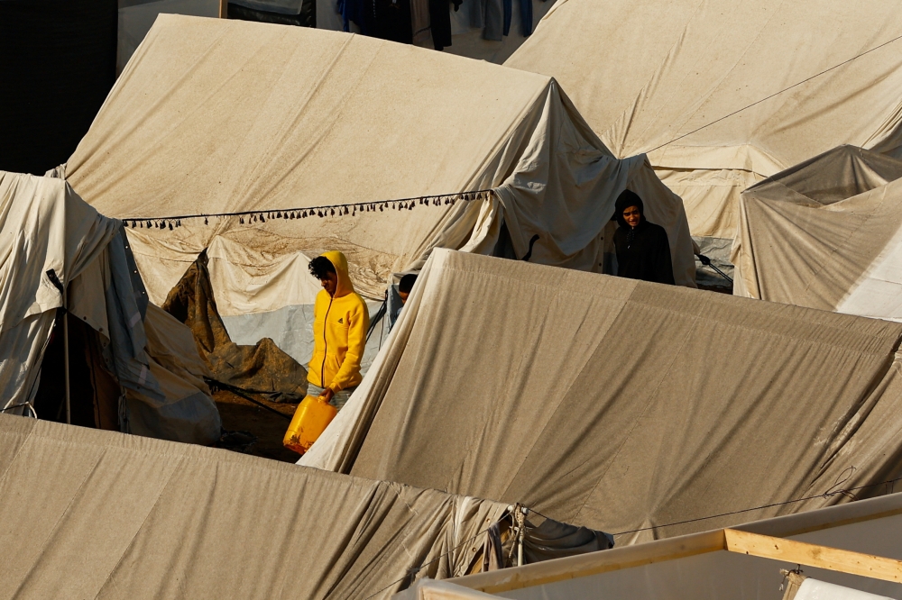 People walk at a tent camp sheltering displaced Palestinians, amid the ongoing conflict between Israel and Palestinian Islamist group Hamas, following a rainfall, in Khan Younis in the southern Gaza Strip, November 14, 2023.  — Reuters pic