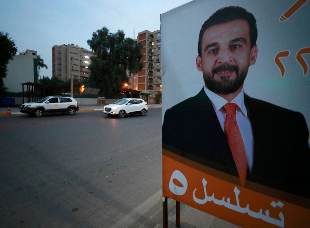 Vehicles drive past a billboard showing Iraqi Parliament Speaker Mohamed al-Halbussi, who is running in the local elections in December, along a main throughfare in Baghdad on November 14, 2023. — AFP pic