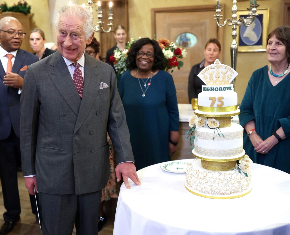 Britain's King Charles III reacts whils holding a knife as he prepares to cut a birthday cake as he attends his 75th birthday party, hosted by the Prince's Foundation, at Highgrove House in Tetbury, western England on November 13, 2023. — AFP pic