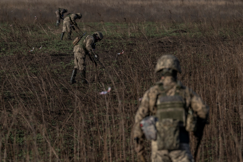 Ukrainian sappers inspect a field for explosive devices, amid Russia's attack on Ukraine, in Kherson region, Ukraine November 9, 2023. — Reuters pic