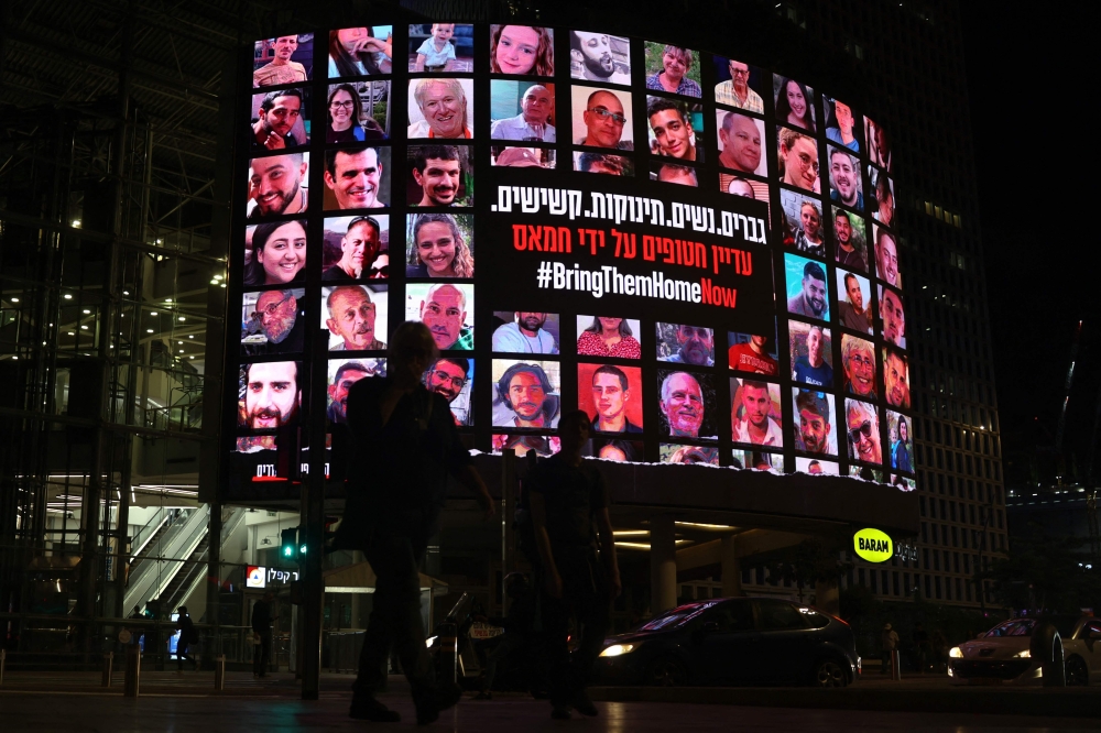 A billboard bearing portraits of Israeli hostages taken by Palestinian militants in the October 7 attack during a demonstration calling for their release in Tel Aviv on November 15, 2023. — AFP pic