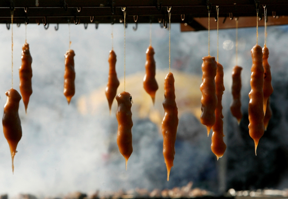Freshly made Churchkhela, traditional Georgian sweets made of walnuts sewn on a string and dipped in thickened grape juice, are seen during Tbilisoba city day celebration in Tbilisi, Georgia, October 21, 2007. — Reuters pic 