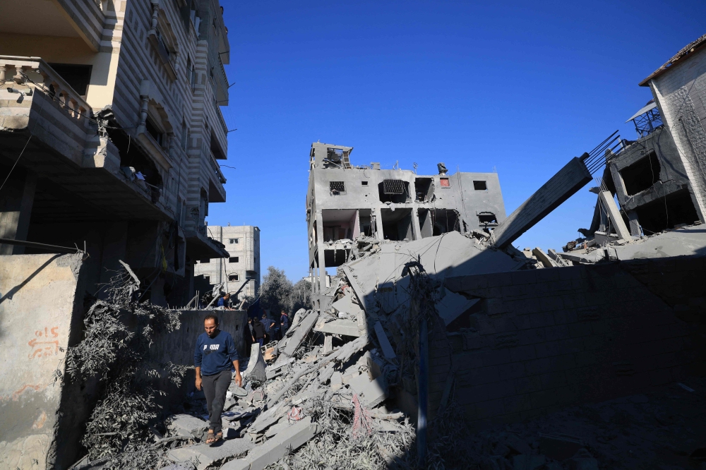 People inspect the damage at the Nuseirat refugee camp in the central Gaza Strip on November 17, 2023, amid ongoing battles between Israel and the militant group Hamas. — Reuters pic